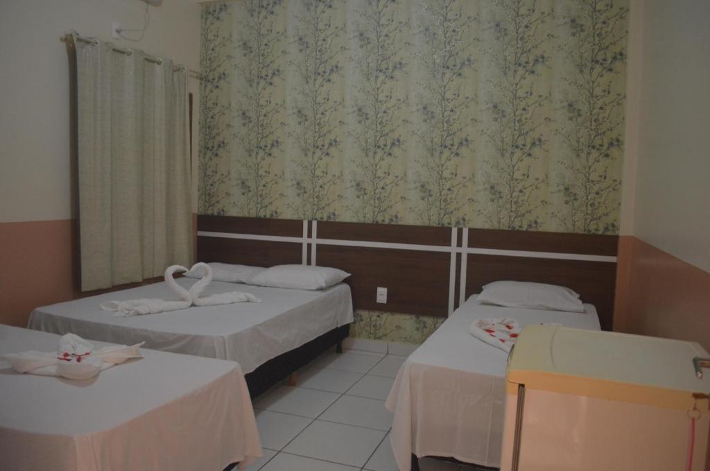 a hotel room with two beds and a window at Hotel Juruá in Cruzeiro do Sul