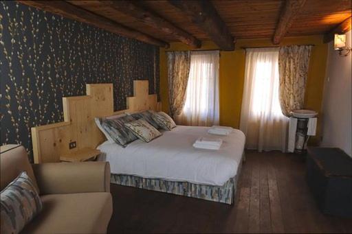- une chambre avec un grand lit et un canapé dans l'établissement Casetta Al Ponte, à Cison di Valmarino