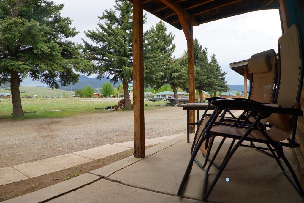 a table and chairs on a porch with a view of a road at Eagle Nest Fly Shack & Lodge in Eagle Nest