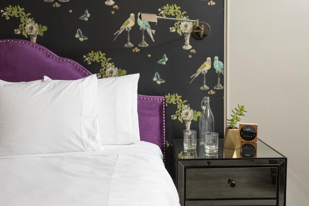 a bedroom with a bed with a purple headboard and a side table at Wicker Park Inn in Chicago