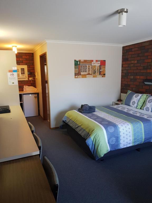 a bedroom with a bed and a table and chairs at Coorrabin Motor Inn in Stawell
