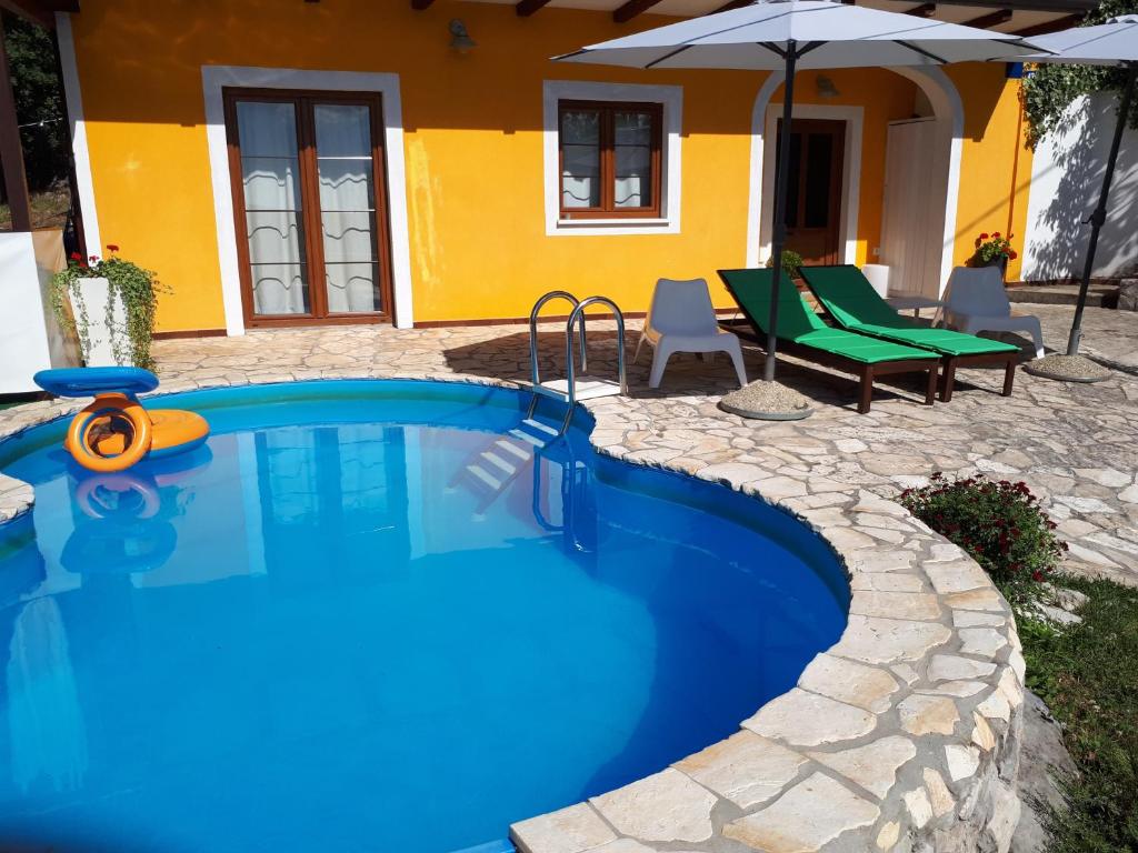 - une piscine en face d'une maison avec une terrasse dans l'établissement Casa Deborah, à Ripenda Kras
