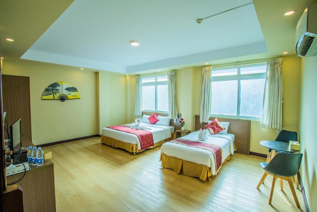 仰光Golden Gate China Town Hotel的一间酒店客房,设有两张床和电视