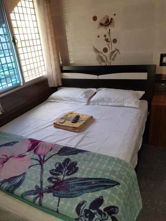 ein Bett mit einem Tablett und einer Decke darauf in der Unterkunft Rks Homestay in Hampi