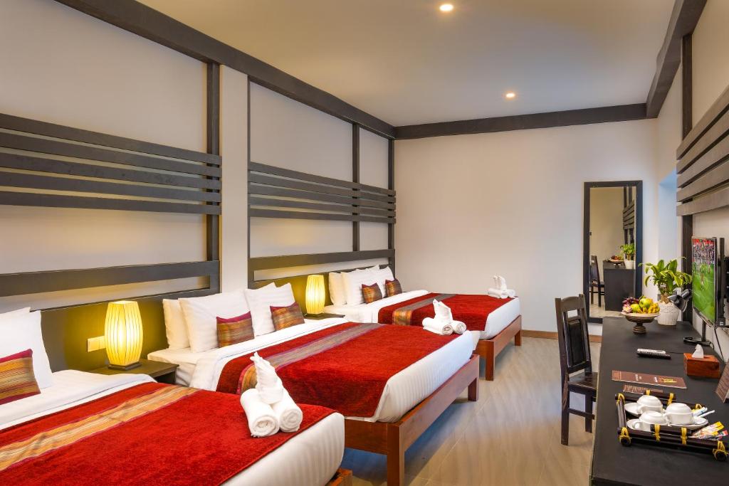Postel nebo postele na pokoji v ubytování Reveal Angkor Hotel
