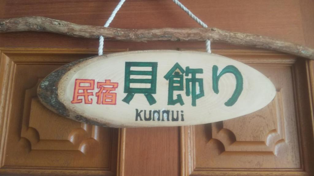 ein Schild, das an einer Tür hängt und darauf geschrieben ist. in der Unterkunft Minshuku Kaikazari Kunnui in Oshamambe