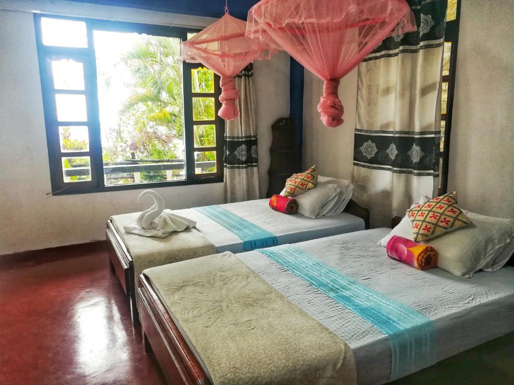 2 camas en una habitación con 2 ventanas en White Monkey Dias Rest, en Haputale