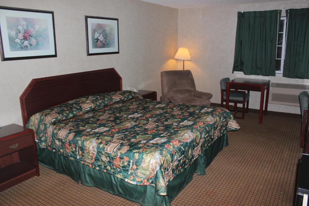 ein Hotelzimmer mit einem Bett und einem Stuhl in der Unterkunft Garden City Inn in Garden City