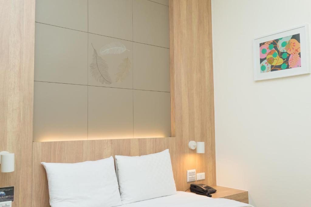 1 dormitorio con cama blanca y cabecero en Bowa Hotel Penghu, en Magong