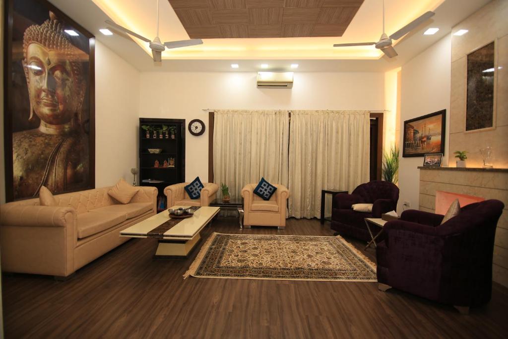 a living room filled with furniture and a large statue at Avanti Tenantry-Luxurious Service Apartments in New Delhi