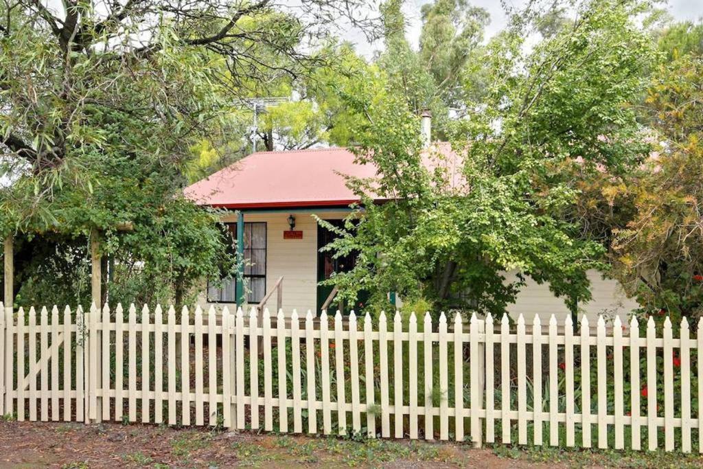 a white picket fence in front of a small house at Auburn Hideaway Clare Valley in Auburn