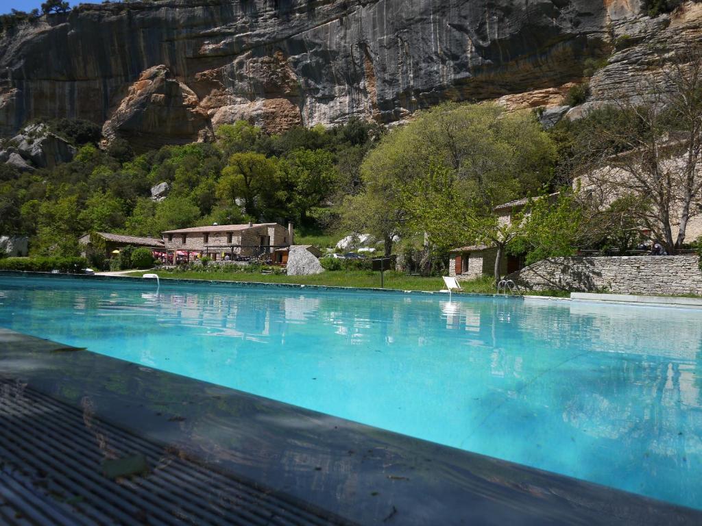 a large pool of blue water with a mountain in the background at Auberge des Seguins in Buoux