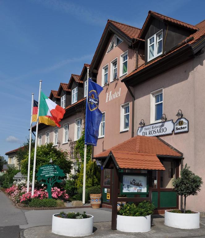 a hotel with flags in front of a building at Hotel da Rosario in Bad Neustadt an der Saale