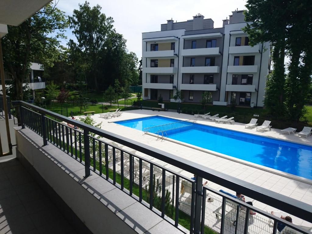 a balcony with a swimming pool and a building at Apartament 13 Ustronie Morskie in Ustronie Morskie