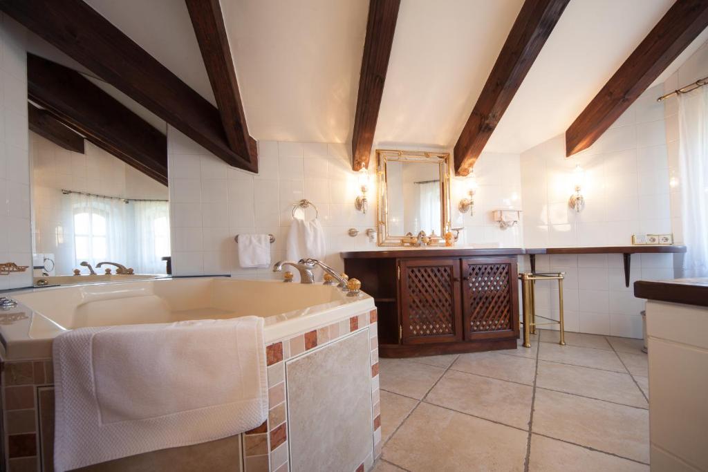 ein großes Bad mit einem Waschbecken und einer Badewanne in der Unterkunft Romantik Villa in Andechs