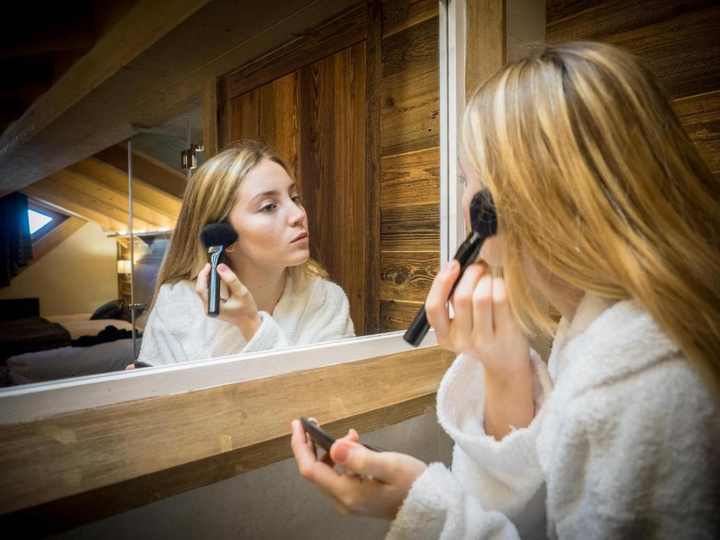 a woman is looking at her reflection in a mirror at Residence Livigno MyHolidayLivigno in Livigno