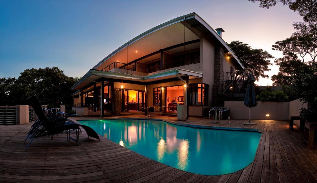 a house with a swimming pool in front of a house at One On Hely in Mtunzini