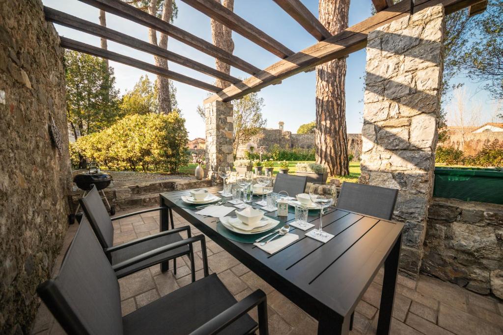 a table and chairs on a patio with a view of a yard at Gardenhouse Sarzana in Sarzana