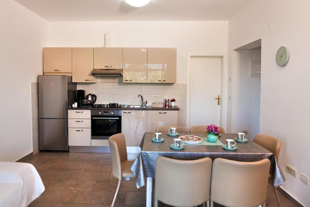 a small kitchen with a table and chairs in a kitchen at Apartment Villa Lidija in Lovran