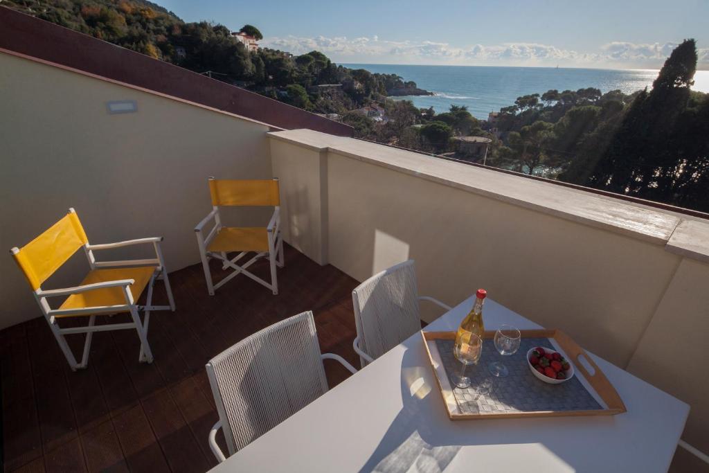 balcón con mesa, sillas y vistas al océano en Terrazza Blue Line, en Tellaro