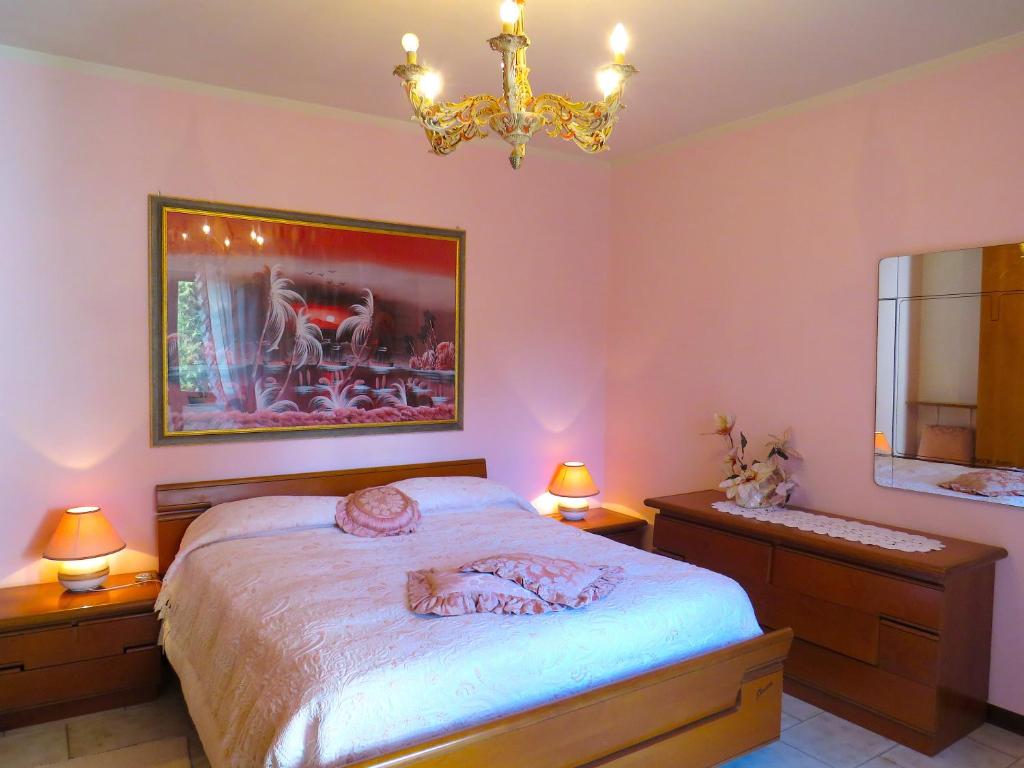 una camera con letto, lampadario a braccio e specchio di Grazia Appartamento Family a Barga