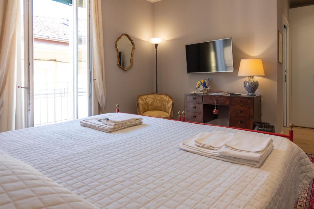 Un dormitorio con una cama blanca con toallas. en La Nuova Corte Rooms, en Verona