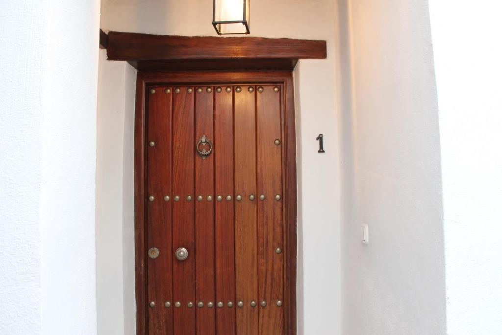 una puerta de madera en un pasillo con una luz sobre ella en Apartamentos Rurales Rosendo: La Madre Selva en Capileira