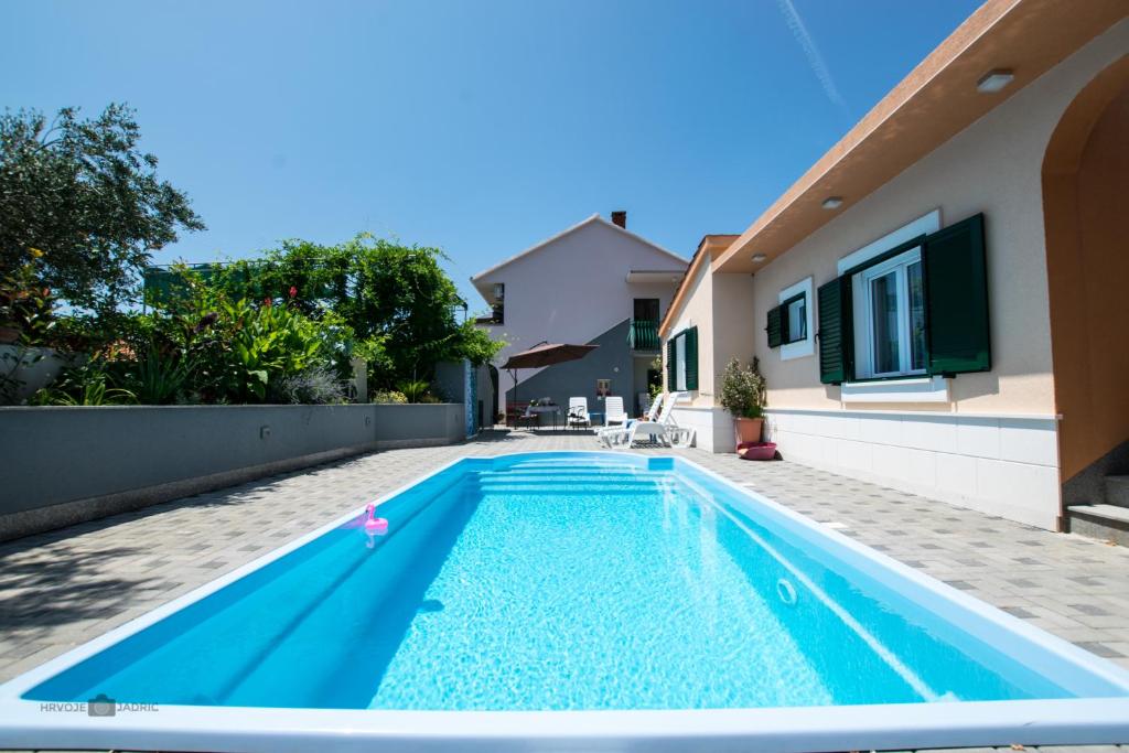 a swimming pool in the backyard of a house at Summer rental house "Kava" in Okrug Donji
