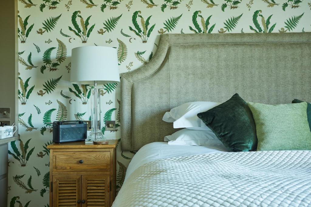 a bedroom with a bed with a lamp on a night stand at The Duncombe Arms in Ellastone