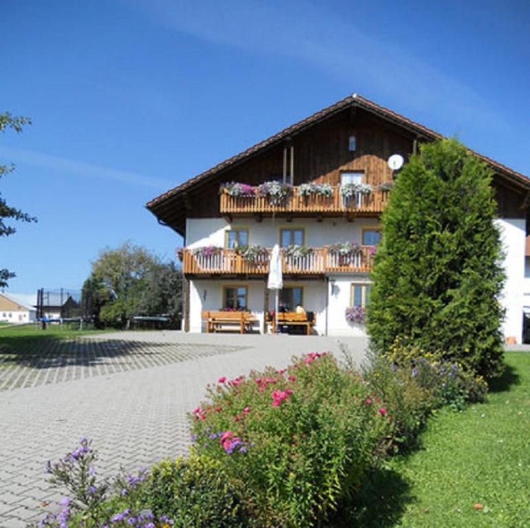 a large house with a balcony on the side of it at Der Bauernhof Beim Bergler in Neureichenau