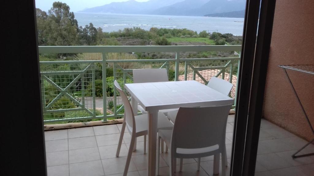 einen weißen Tisch und Stühle auf einem Balkon mit Aussicht in der Unterkunft Studio A Suarella in Saint-Florent