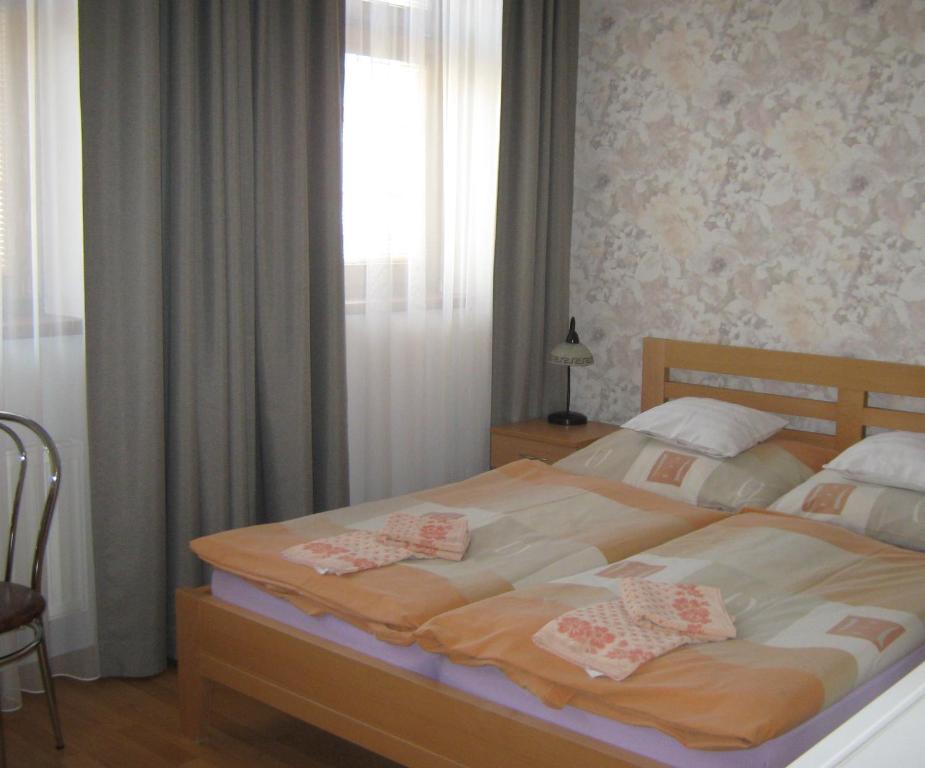 Un dormitorio con una cama grande con flores. en Penzion U Radnice en Kyjov