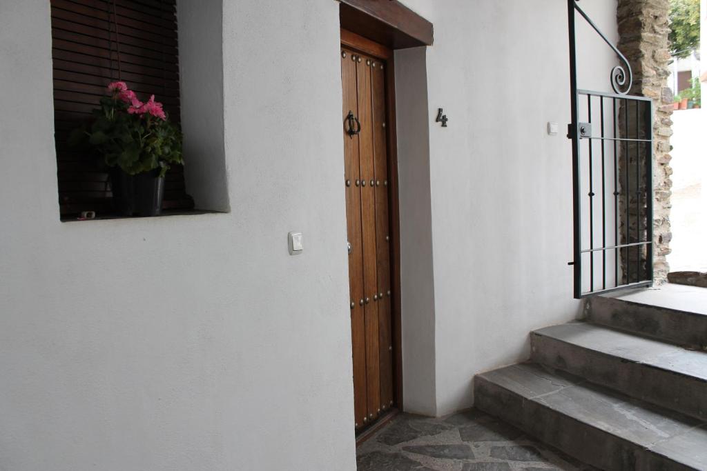 eine Tür zu einem Haus mit einer Topfpflanze daneben in der Unterkunft Apartamentos Rurales Rosendo: El Azahar in Capileira