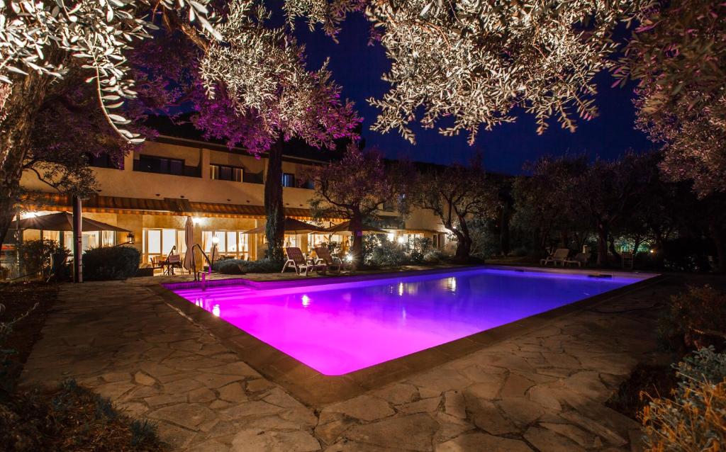 a swimming pool lit up purple at night at La Picholine in Nyons