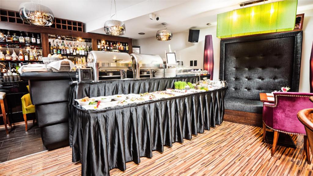 ein Restaurant mit einer Theke mit Essen darauf in der Unterkunft Don Prestige Residence in Posen