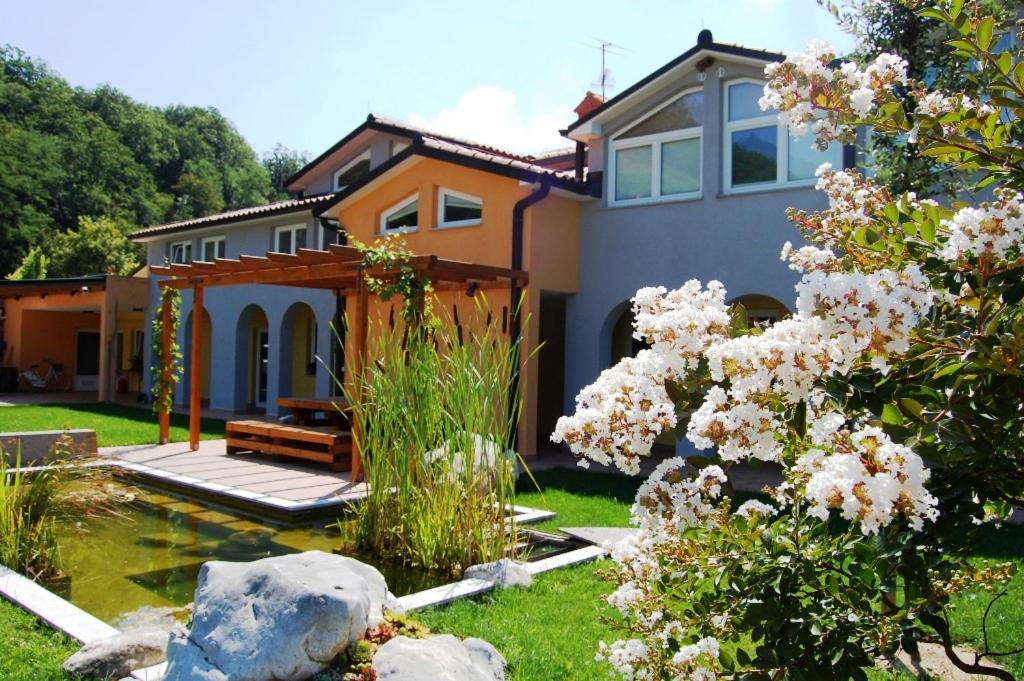 ein Haus mit einem Teich im Hof in der Unterkunft Hiša posebne Sorte in Kodreti