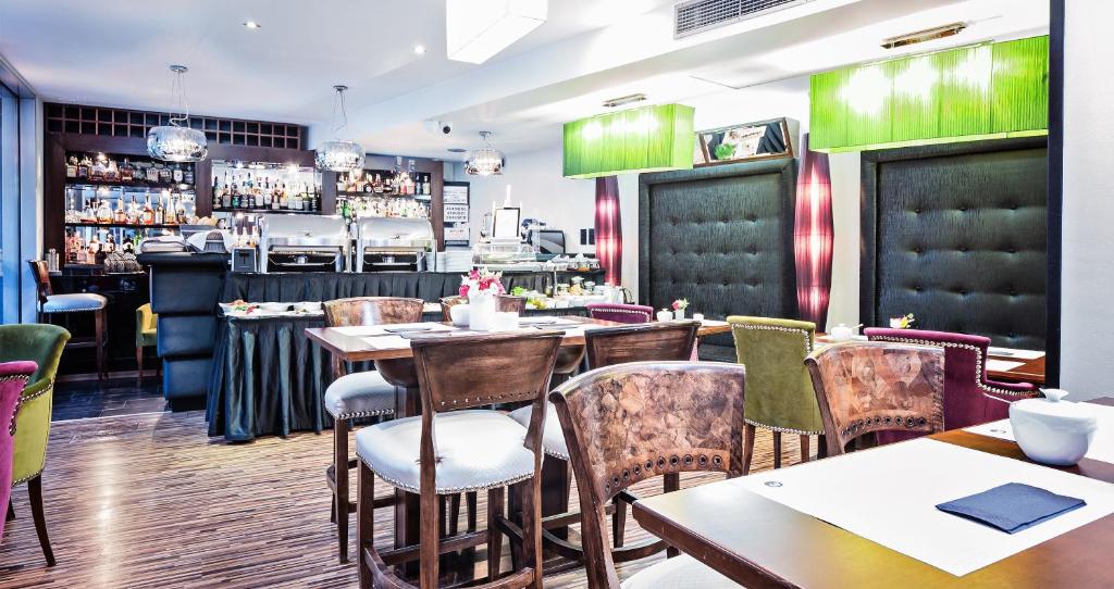 ein Restaurant mit Tischen und Stühlen und einer Bar in der Unterkunft Don Prestige Residence in Posen