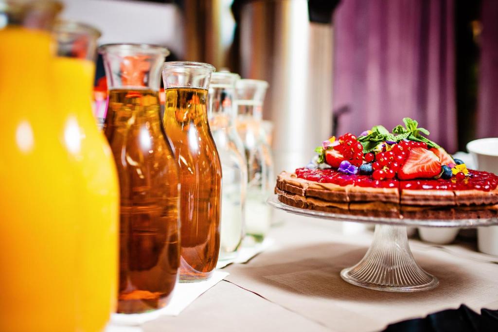 einen Tisch mit einem Kuchen mit Erdbeeren darüber in der Unterkunft Don Prestige Residence in Posen