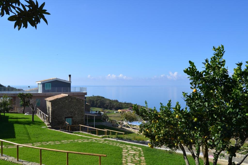 widok na wodę z domu z drzewem w obiekcie Borgo Rosso di Sera Resort w mieście San Lucido