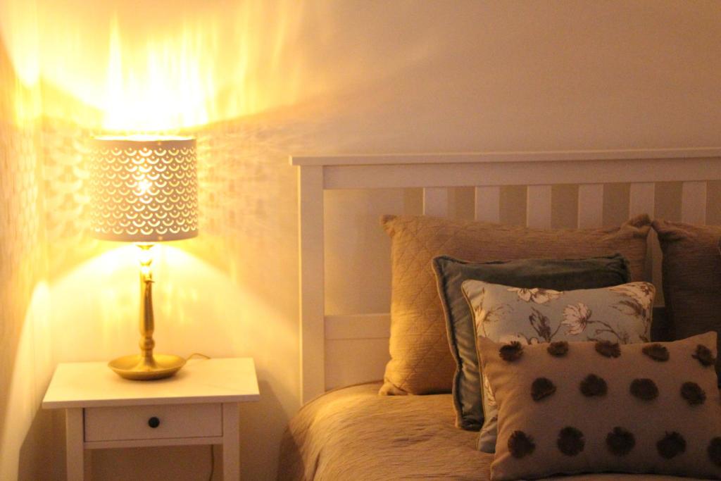ein Schlafzimmer mit einem Bett mit einer Lampe auf einem Nachttisch in der Unterkunft Marquinhas House - A Queijeira in Oliveira do Hospital