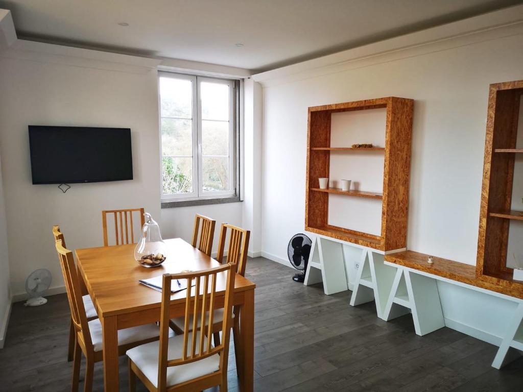 a dining room with a table and chairs and a tv at Sintra Design Apartment_Palácio da Pena in Sintra