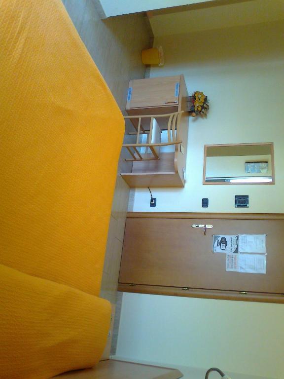 Pokój z łóżkiem i biurkiem z żółtym kocem w obiekcie Life Hotel w mieście Ariano Irpino