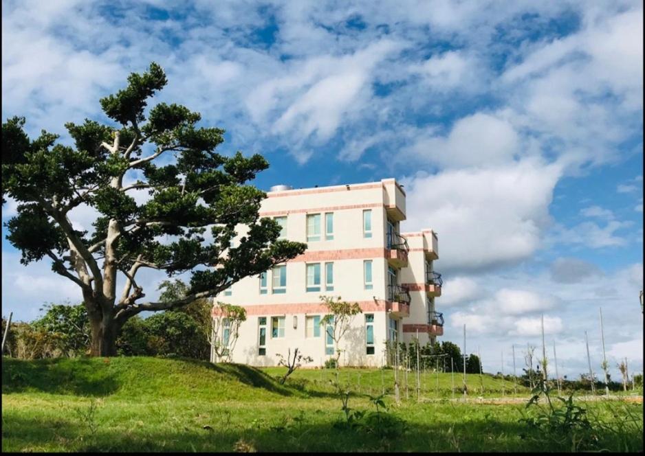 una casa en la cima de una colina con un árbol en Full Moon Resort, en Hengchun