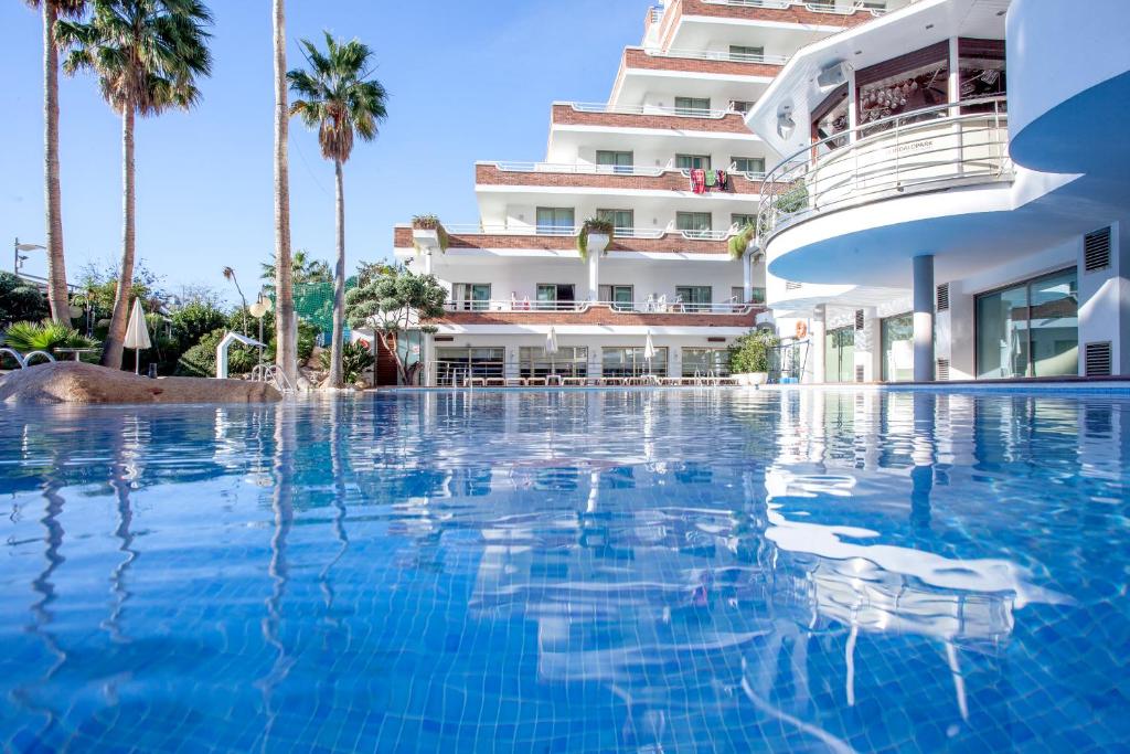 a swimming pool in front of a hotel at Hotel Indalo Park in Santa Susanna