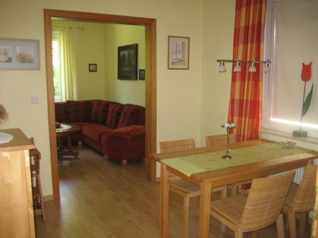 ein Wohnzimmer mit einem Tisch und einem Sofa in der Unterkunft Ferienhaus "Antje" in Bad Zwischenahn
