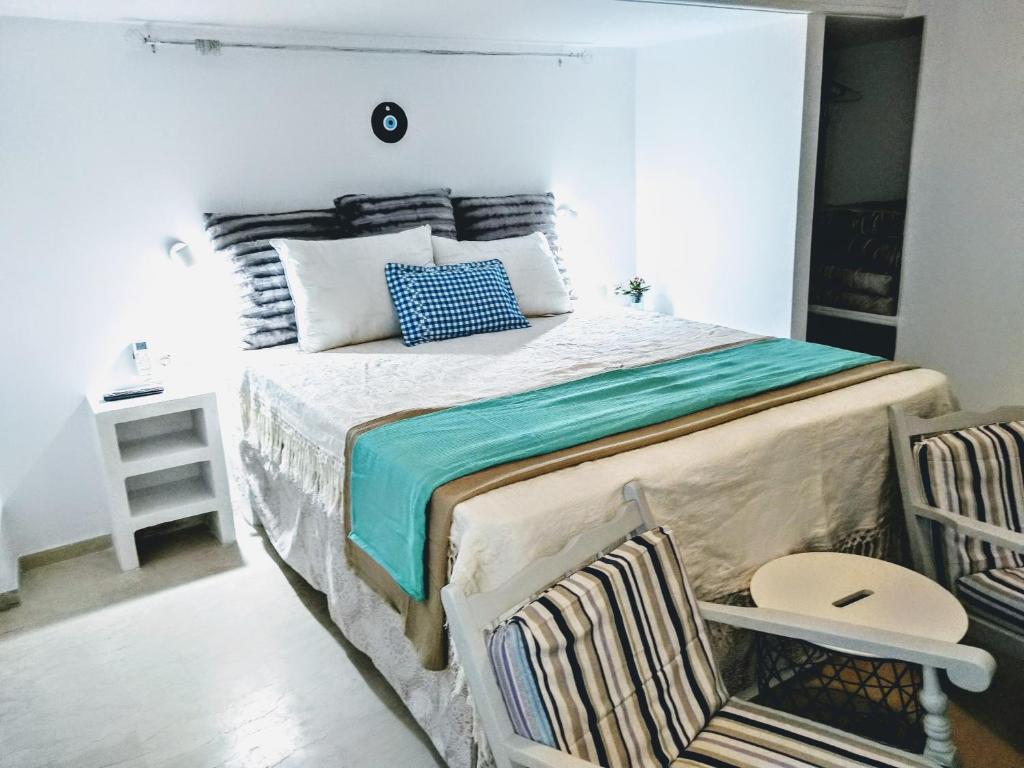 ein Schlafzimmer mit einem großen Bett mit einem Tisch und einem Stuhl in der Unterkunft Zamboli in Chania