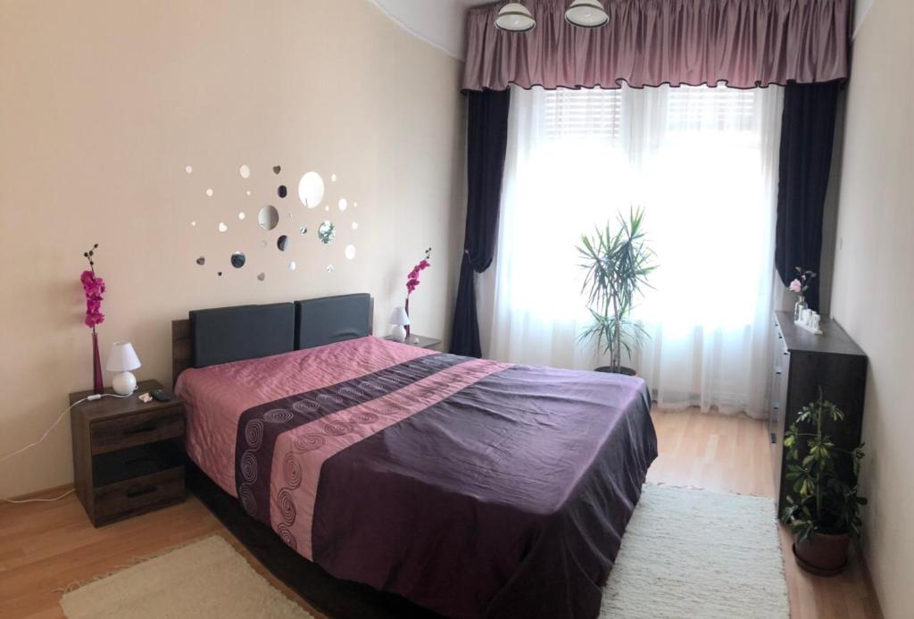 1 dormitorio con 1 cama con colcha púrpura en Corso Apartman en Kaposvár