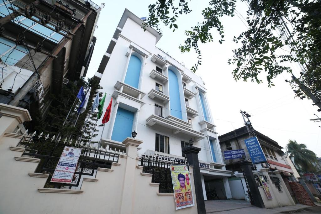 a white building with blue windows and balconies at Hotel Priya Palace in Guwahati
