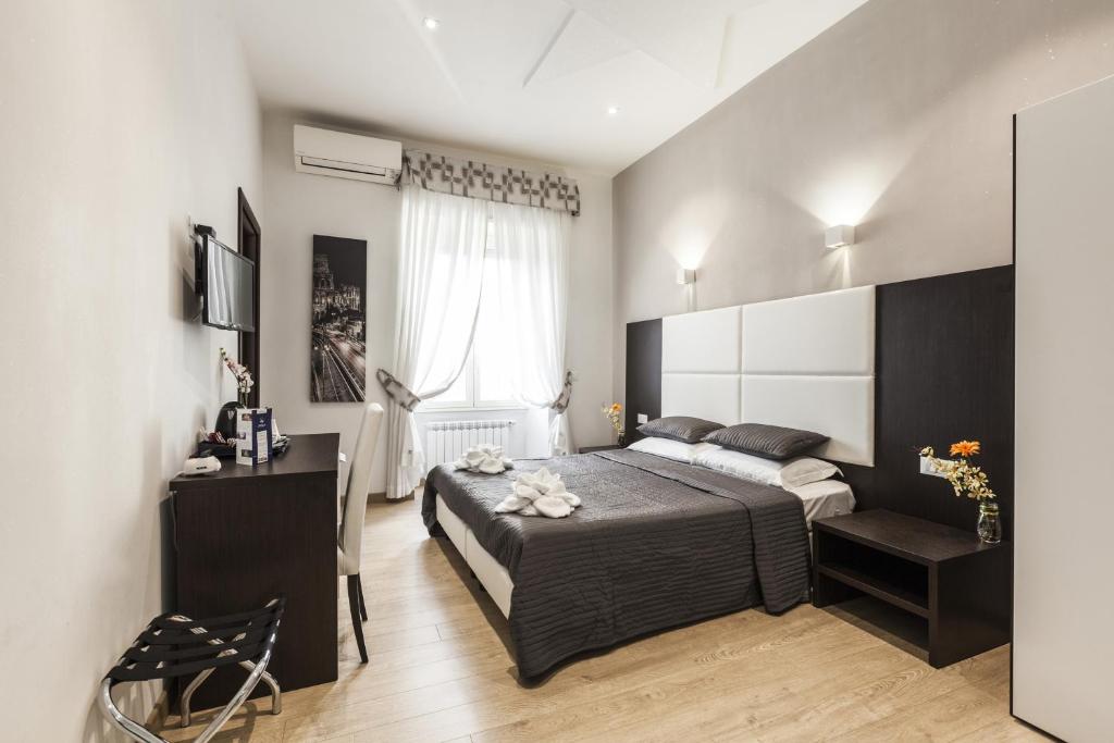 a bedroom with a large bed and a desk at Stardust Rome Guest House in Rome