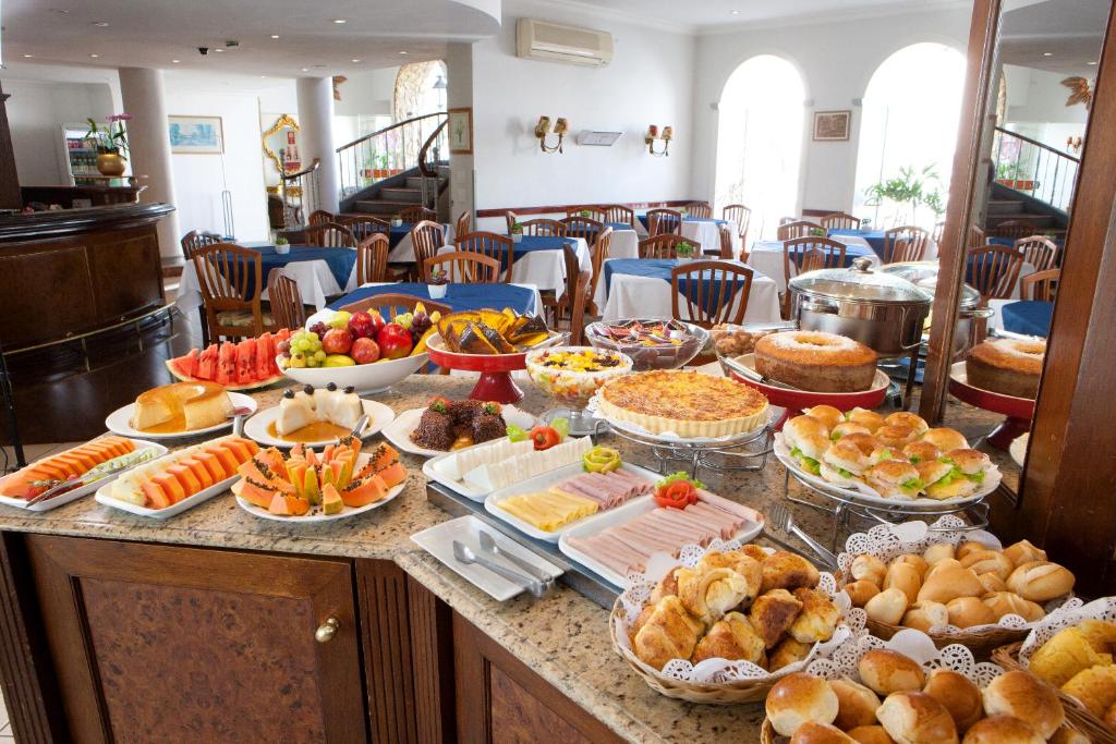 um buffet com muitos tipos diferentes de comida em uma mesa em Hotel Colonial Plaza em Itu